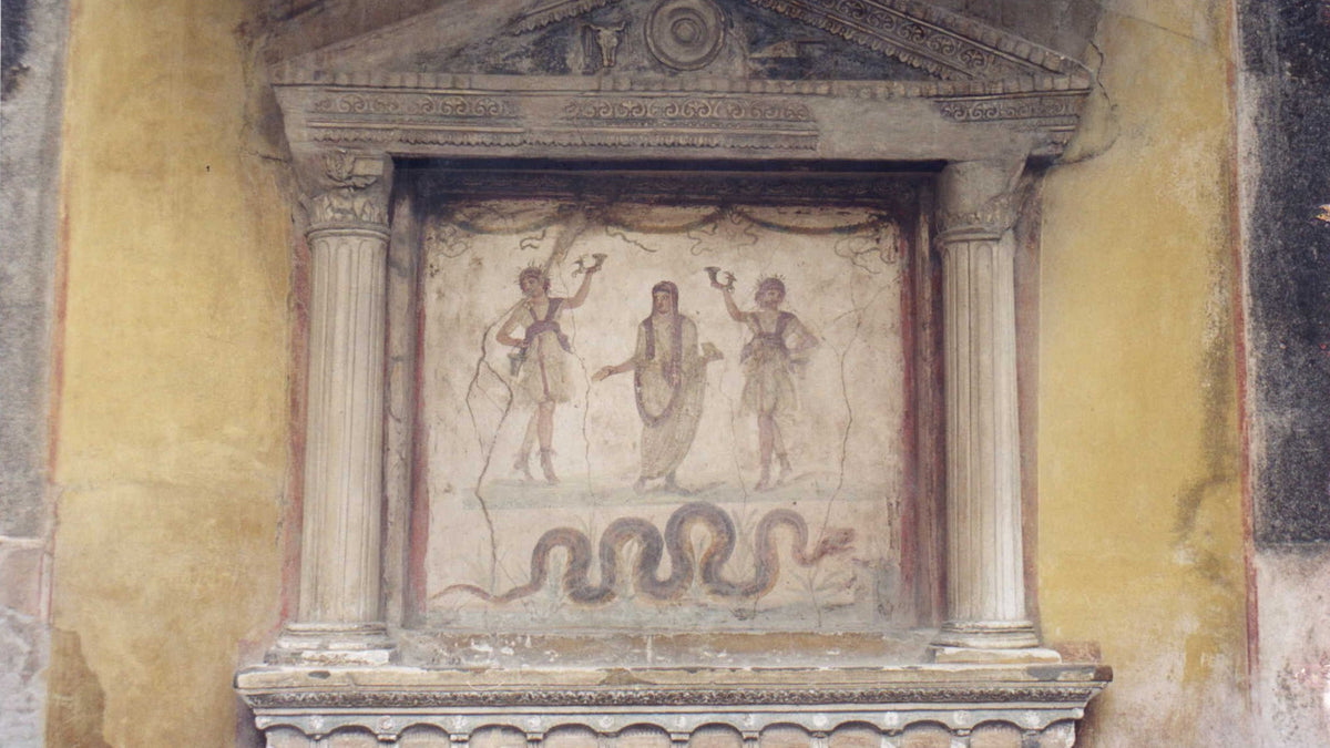 Laraire antique peint de la maison des Vettii à Pompéi : deux Lares, un Génie familial et un serpent gardien du foyer, photographie de Patricio Lorente, CC BY-SA 2.5, recadrée