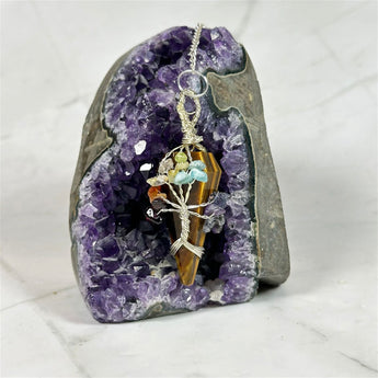 Pendule 7 chakras en Œil de Tigre - Aeternum - a close up of a person on a snowboard - # boutique ésoterisme# - #wicca#