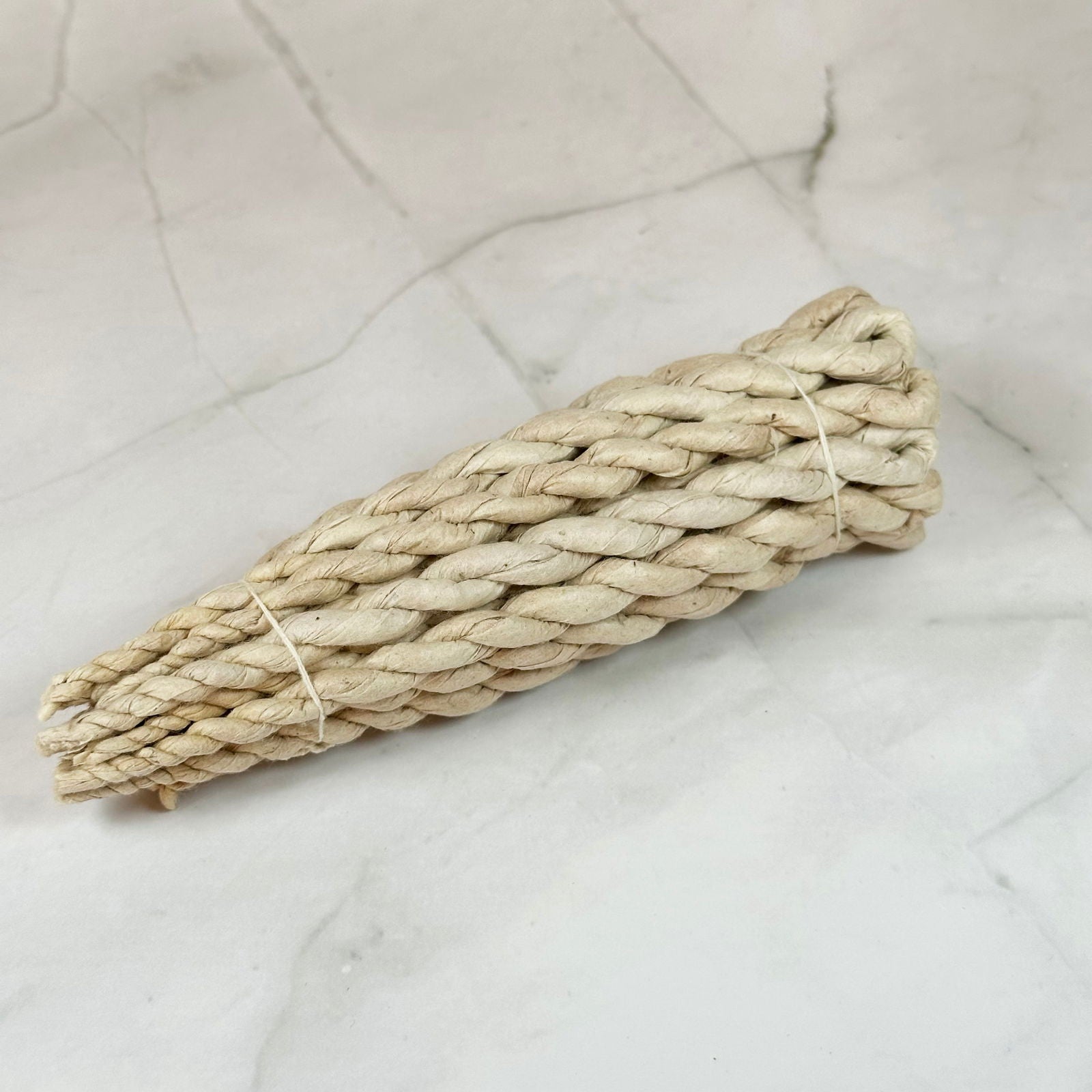 Encens en corde - 1er chakra (ancrage) - Aeternum - a piece of bread sitting on top of a white cloth  - # boutique ésoterisme# - #wicca# 