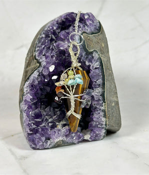 Pendule 7 chakras en Œil de Tigre - Aeternum - a close up of a person on a snowboard  - # boutique ésoterisme# - #wicca# 