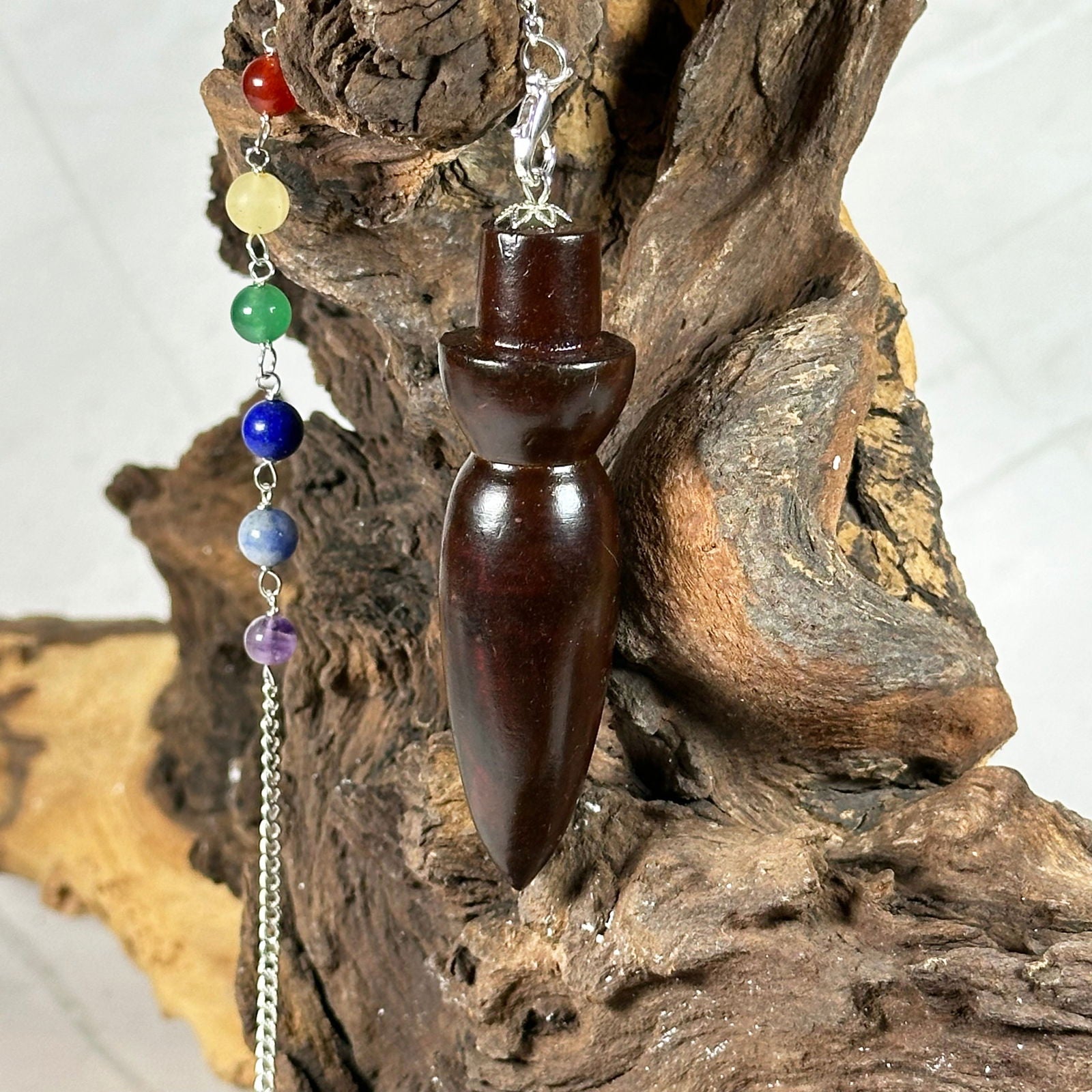 Pendule 7 chakras en bois de rose - Aeternum - a close up of a chocolate cake on a table  - # boutique ésoterisme# - #wicca# 
