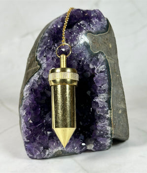 Pendule Témoin Bullet en cuivre doré - Aeternum - a person is holding a snowboard in the snow  - # boutique ésoterisme# - #wicca# 
