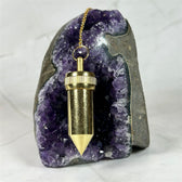 Pendule Témoin Bullet en cuivre doré - Aeternum - a person is holding a snowboard in the snow  -