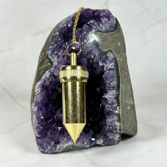 Pendule Témoin Bullet en cuivre doré - Aeternum - a person is holding a snowboard in the snow  - # boutique ésoterisme# - #wicca# 