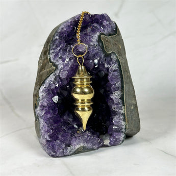 Pendule Témoin de yoga en cuivre doré - Aeternum - a statue of a person with a snow board  - # boutique ésoterisme# - #wicca# 