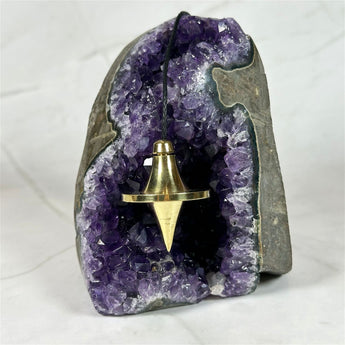 Pendule UFO en laiton doré - Aeternum - a statue of a person in a purple outfit  - # boutique ésoterisme# - #wicca# 