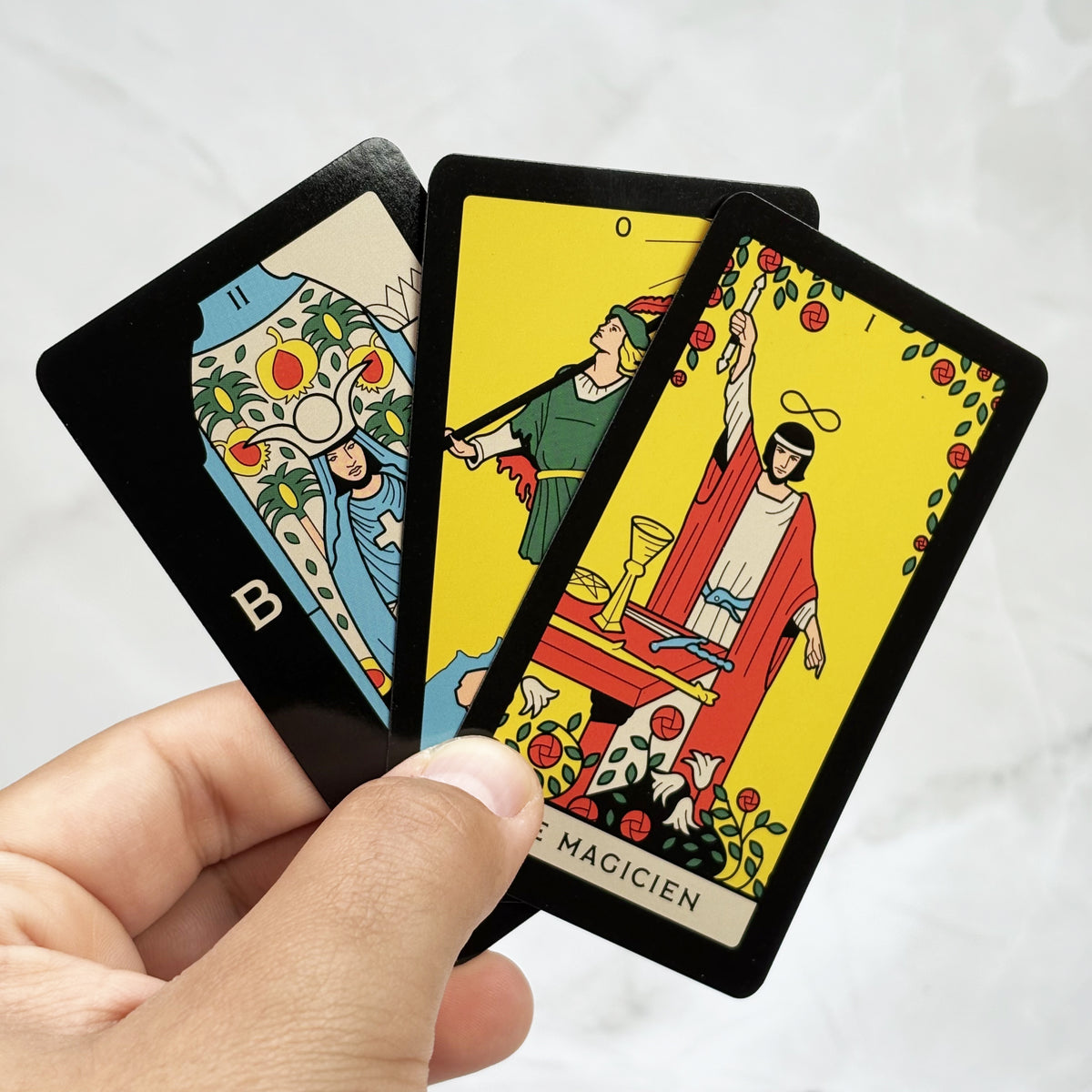 Tres cartas del Mini Tarot sostenidas en una mano.